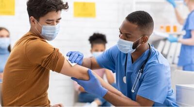 enfermera preparando el brazo del paciente para la vacuna