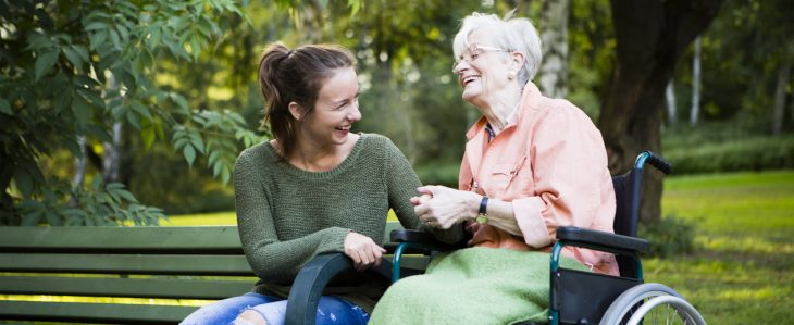 Woman sitting with an elderly woman in a wheelchair