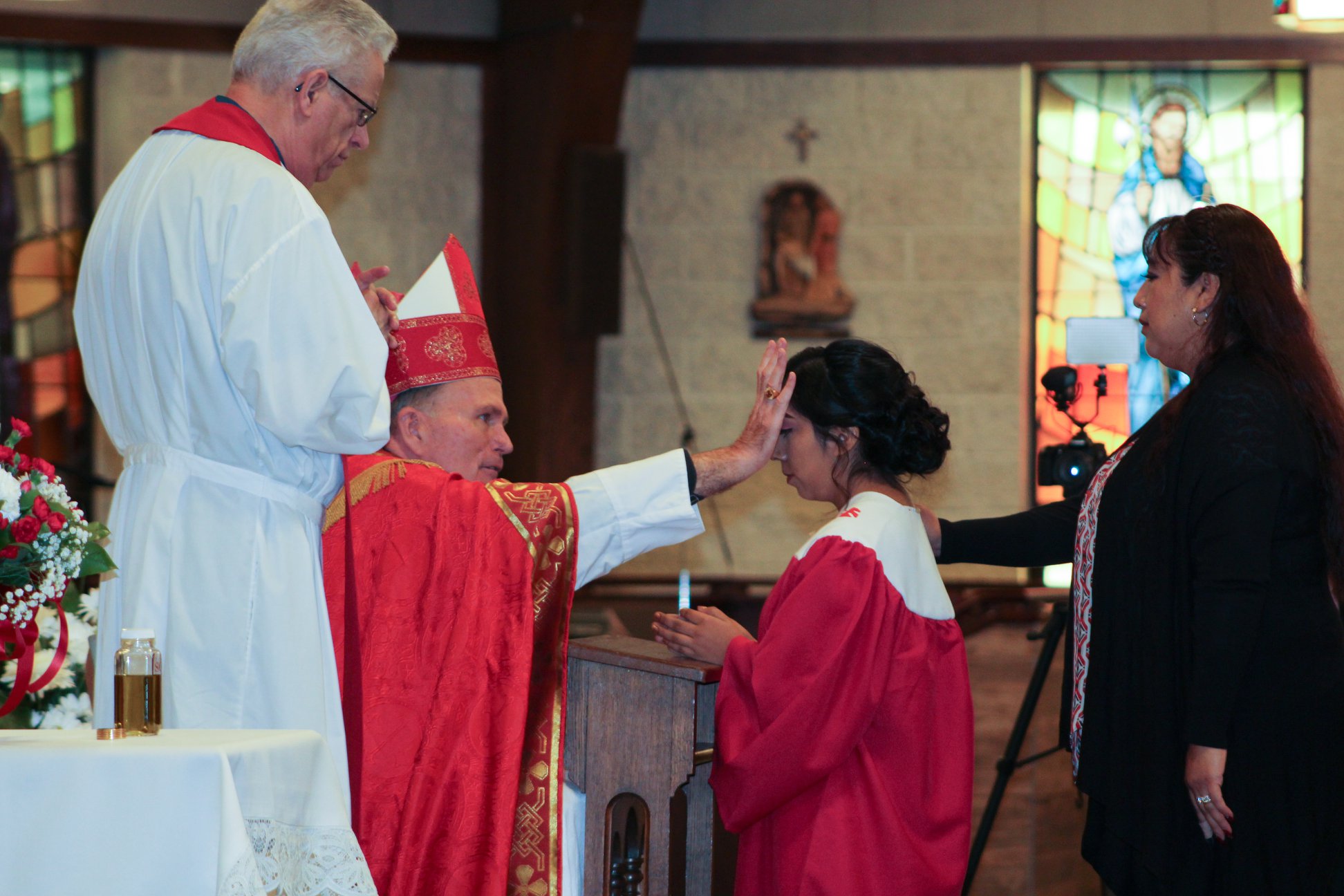 Una imagen de un sacerdote realizando una confirmación.